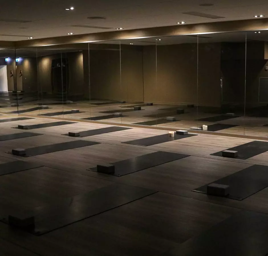 Soul yoga studio set up for a class, lights are dim, mats laid out on the floor