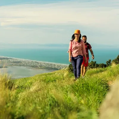 Friends walking in the Port Hills Christchurch with the Christchurch coastline in the background.