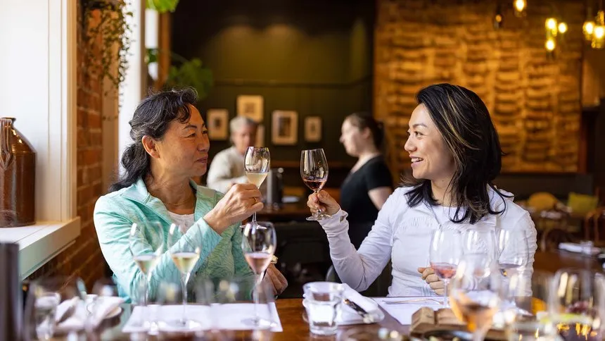 Mother and daughter raising a glass of wine in Cellar Door